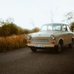 an old car is parked on the side of the road